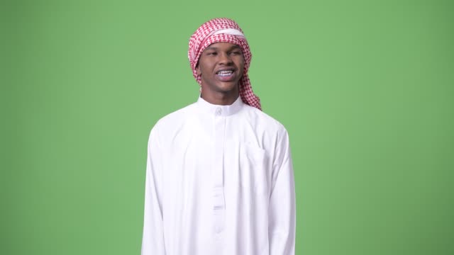 Junge-afrikanische-Mann-tragen-traditionelle-muslimische-Kleidung-vor-grünem-Hintergrund
