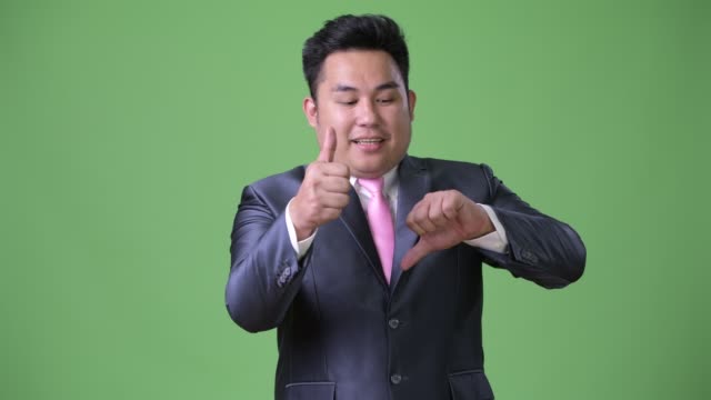 Junge-hübsche-Übergewicht-asiatischen-Geschäftsmann-vor-grünem-Hintergrund