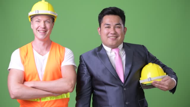 Skandinavische-Mann-Bauarbeiter-und-asiatischen-Geschäftsmann-arbeiten-zusammen