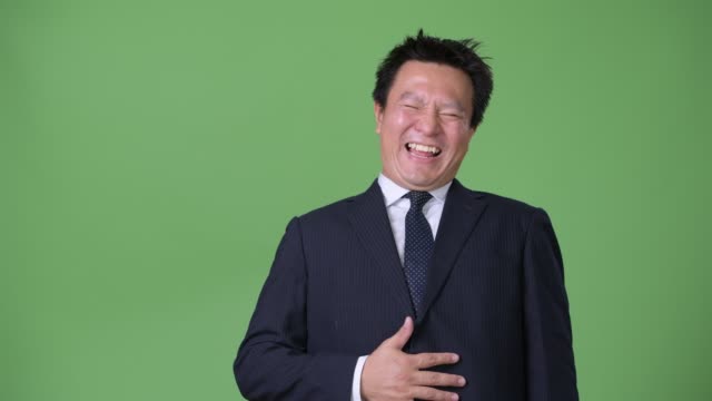 Mature-Japanese-businessman-against-green-background