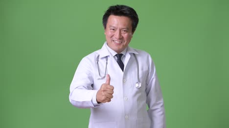 Doctor-maduro-hombre-japonés-sobre-fondo-verde