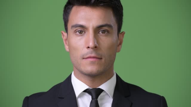 Junge-hübsche-Hispanic-Geschäftsmann-vor-grünem-Hintergrund