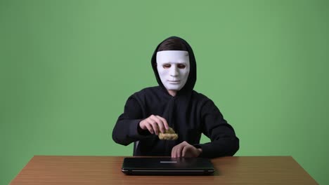 Junge-Teenager-Computer-Hacker-vor-grünem-Hintergrund