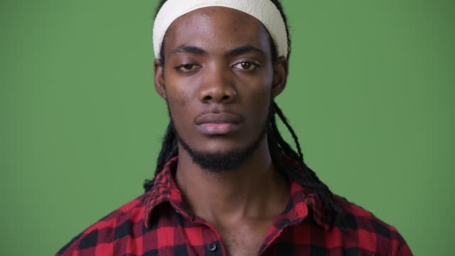 Young-handsome-African-man-with-dreadlocks-against-green-background
