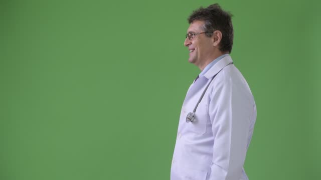 Reife,-gut-aussehender-Mann-Arzt-vor-grünem-Hintergrund
