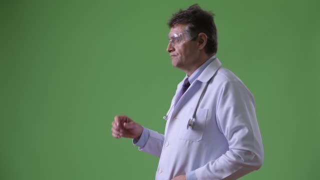 Reife,-gut-aussehender-Mann-Arzt-vor-grünem-Hintergrund