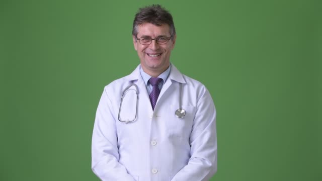 Médico-hombre-guapo-maduro-sobre-fondo-verde