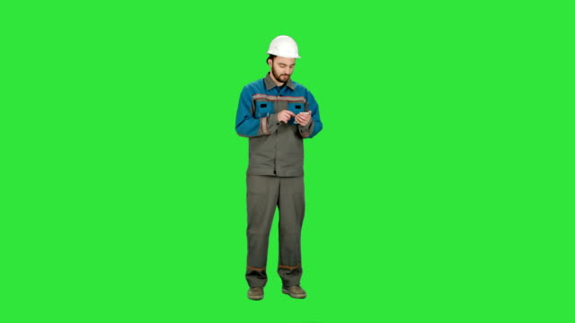 Construction-worker-using-cell-phone-to-send-message-on-a-Green-Screen,-Chroma-Key