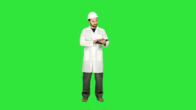 Industrial-Engineer-Using-Tablet,-talk-on-camera-on-a-Green-Screen,-Chroma-Key