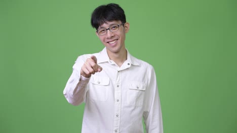 Junge-asiatische-Geschäftsmann-lächelnd-und-deutete-auf-Kamera