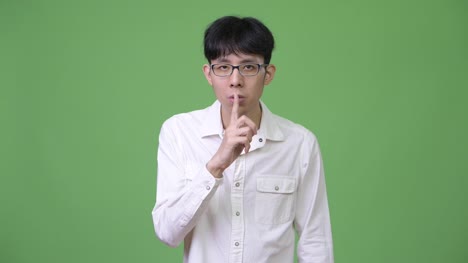 Junge-asiatische-Geschäftsmann-mit-Finger-auf-die-Lippen