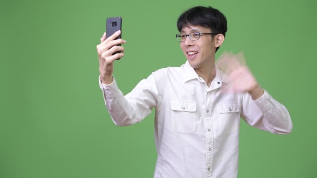 Glücklich-junge-asiatische-Geschäftsmann-lächelnd-dabei-Videoanruf