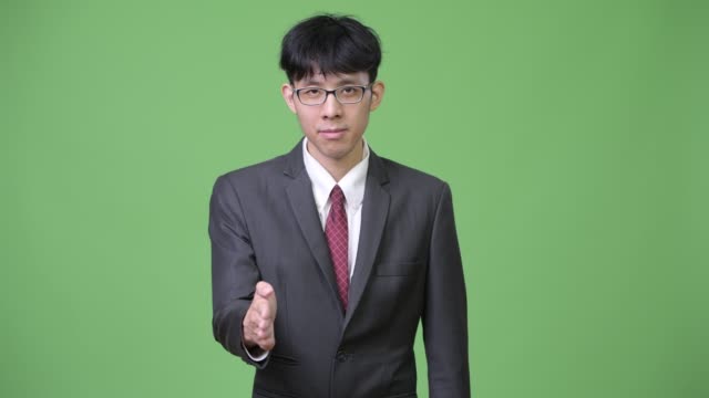 Young-Asian-ejecutivo-dando-estrechar-las-manos