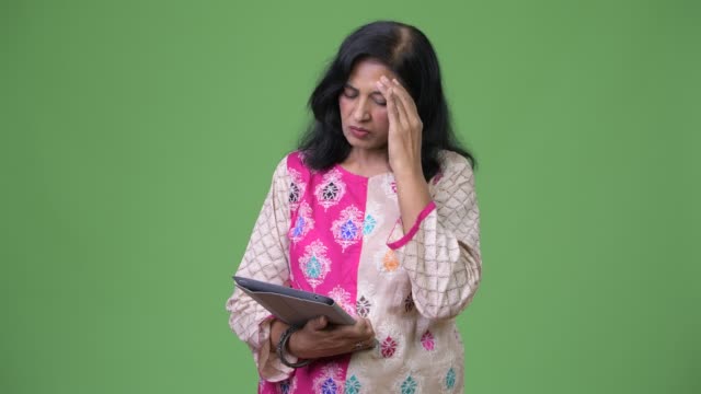 Reife-betonte-Indianerin-mit-digital-Tablette-und-immer-schlechte-Nachrichten