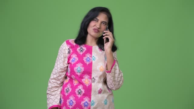 Reife-schöne-Inderin-denken-während-des-Gesprächs-am-Telefon