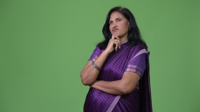 Madura-hermosa-mujer-India-pensando-mientras-se-está-usando-la-vestimenta-tradicional-de-Sari