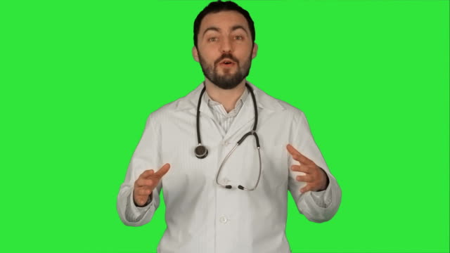 Smiling-doctor-gesturing-thumbs-up-to-camera-on-a-Green-Screen,-Chroma-Key