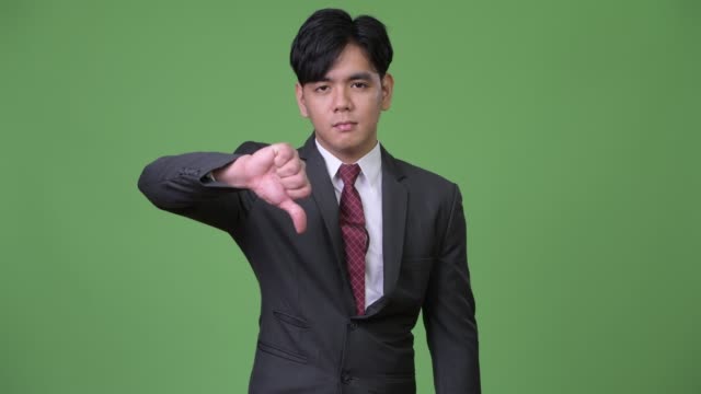 Young-handsome-Asian-businessman-giving-thumbs-down