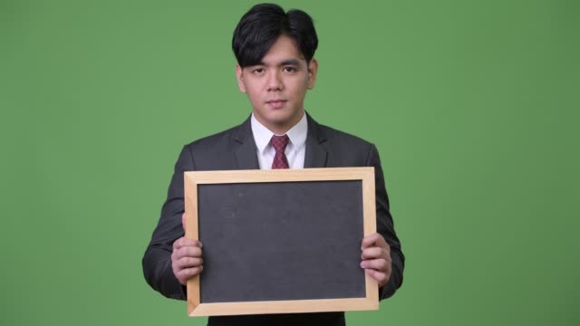 Junge-hübsche-asiatische-Geschäftsmann-zeigt-Tafel