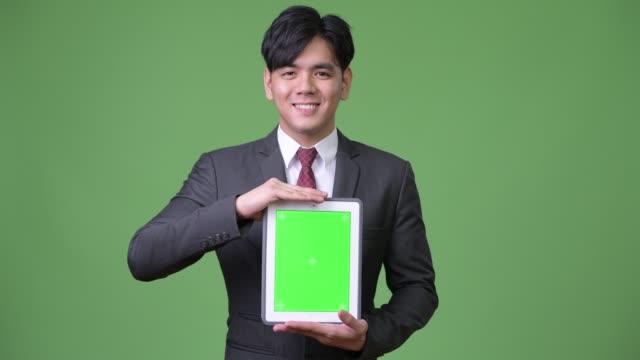 Young-handsome-Asian-businessman-using-digital-tablet