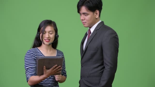 Young-handsome-Asian-businessman-and-young-Asian-woman-working-together