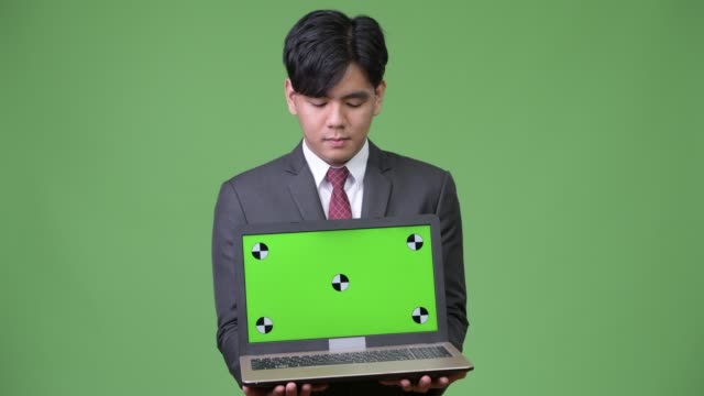 Young-handsome-Asian-businessman-showing-laptop