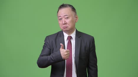 Mature-Japanese-businessman-giving-thumbs-up