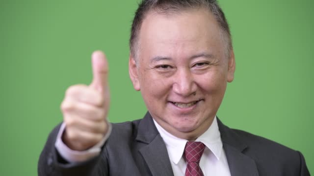 Mature-Japanese-businessman-giving-thumbs-up