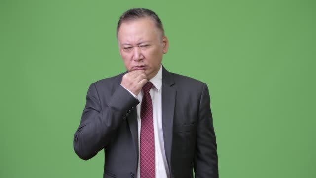 Reife-japanischer-Geschäftsmann-mit-Kopfschmerzen