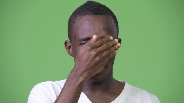 Young-African-man-covering-eyes-not-wanting-to-see-something