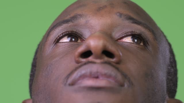 Close-up-shot-of-young-African-man-thinking-while-looking-up