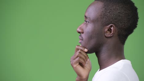 Höhenplan-der-jungen-afrikanischen-Mann-denken-vor-grünem-Hintergrund
