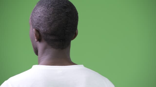 Rear-view-of-young-African-man-against-green-background