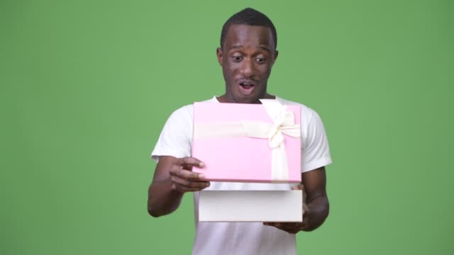 Junge-afrikanische-glücklich-schauen-überrascht-beim-Öffnen-der-Geschenkbox
