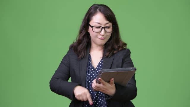 Mature-beautiful-Asian-businesswoman-using-digital-tablet
