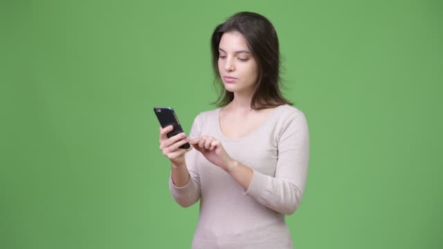 Junge-schöne-Frau-mit-Telefon-vor-grünem-Hintergrund