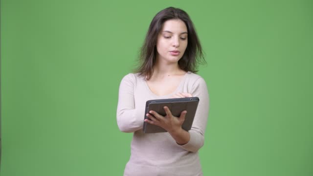 Junge-glücklich-schöne-Frau-denken-bei-der-Verwendung-von-digital-Tablette