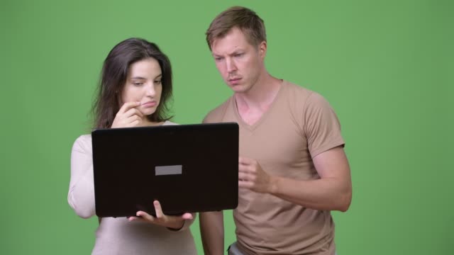 Young-couple-using-laptop-and-thinking-together