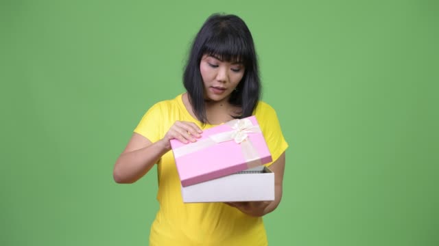 Schöne-glückliche-asiatische-Frau-Geschenk-Box-öffnen