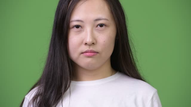 Joven-mujer-asiática-feliz-sonriendo-contra-el-fondo-verde