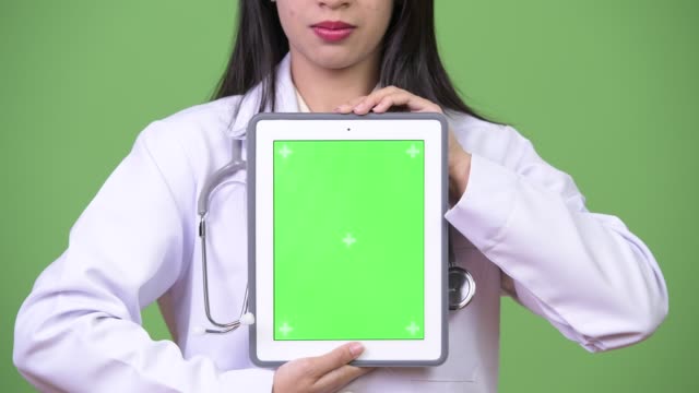 Junge-schöne-asiatische-Frau-Doktor-zeigt-digital-Tablette