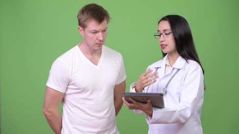 Young-Asian-woman-doctor-giving-consultation-to-young-man-patient
