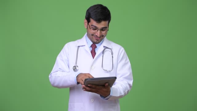Young-handsome-Persian-man-doctor-using-digital-tablet