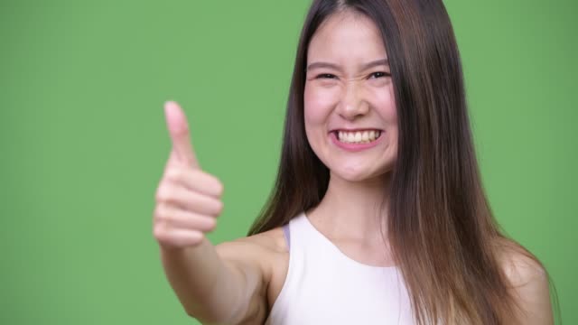 Young-beautiful-Asian-businesswoman-giving-thumbs-up