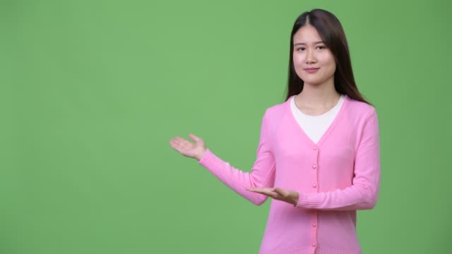 Joven-hermosa-mujer-asiática-mostrando-algo