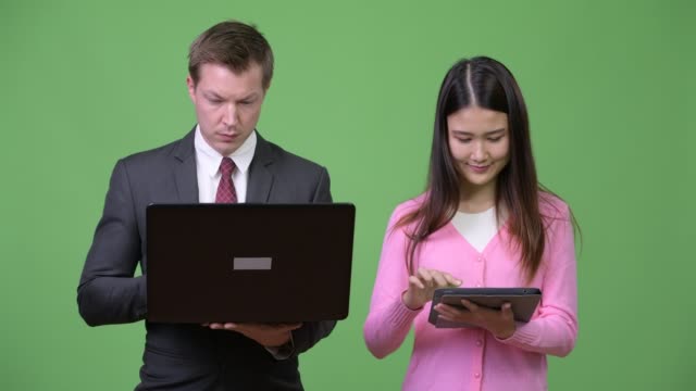 Junge-asiatische-Frau-und-junger-Geschäftsmann-mit-Laptop-und-digital-Tablette-zusammen