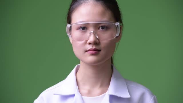 Junge-schöne-asiatische-Frau-Doktor-lächelnd-Schutzbrille-tragen