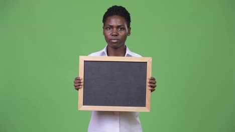 Young-beautiful-African-businesswoman-holding-blackboard