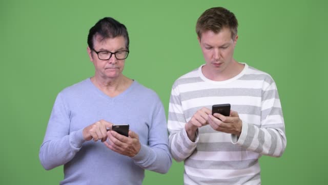 Senior-handsome-man-and-young-handsome-man-using-phone-together