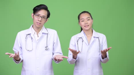 Young-Asian-couple-doctors-shrugging-together